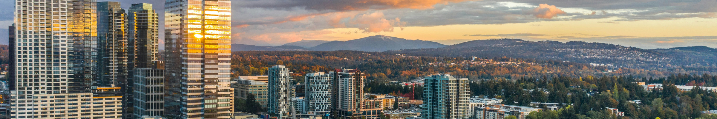 City at sunset during the fall with colorful leaves and mountains in the background